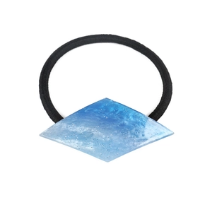 Detail of rhombic acetate hair tie with blue and white marble pattern and glitter