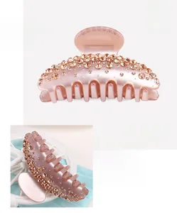 Détail de la pince à cheveux en acétate rose clair avec strass brillants et mesures