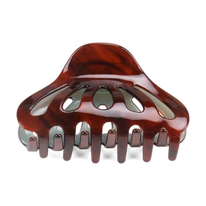 Close-up of polished dark amber tortoiseshell hair claw clip with dense teeth detail