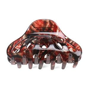 Detailed close-up of red and black marble acetate hair claw clip with cutout design