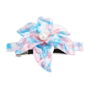 Detail of lily-shaped acetate hair clip with marble texture and pearl centerpiece