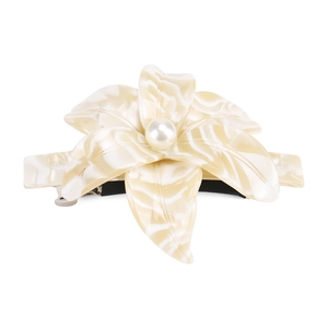 Macro detail of acetate flower hair clip with marble texture and central pearl