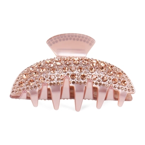 Macro detail of a pale pink acetate hair claw clip with champagne rhinestones