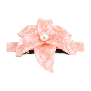 Detailed macro view of pink marble acetate camellia hair clip with center faux pearl