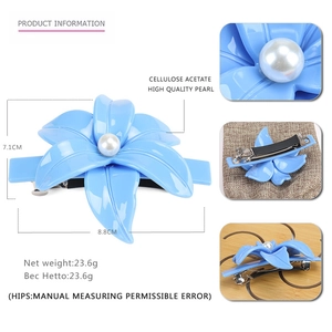 Dettaglio molletta per capelli a fiore in acetato azzurro con perla e clip in metallo