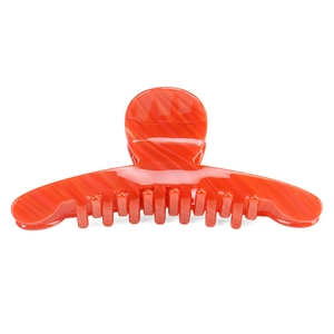 Detailed macro of orange marble textured acetate hair claw with internal metal spring