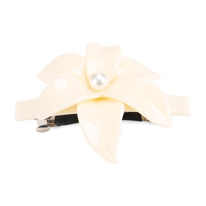 Dettaglio del fermaglio per capelli a camelia in acetato avorio con perla e clip a molla