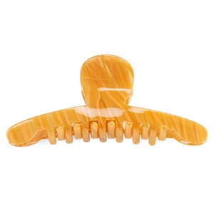 Macro detail of the amber marble acetate shark hair claw with smooth textured finish