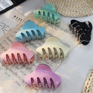 Primo piano di fermagli per capelli lucidi e colorati in varie tonalità pastello trendy