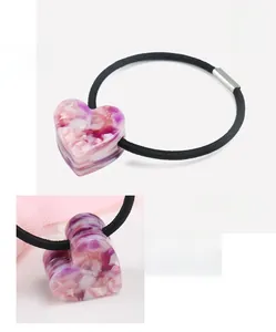 Vue détaillée d'un chouchou cœur en acétate de cellulose avec motif marbre rose