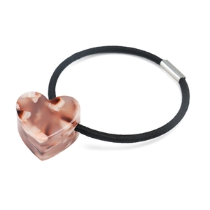 Détail d'un pendentif cœur en écaille rose sur un élastique à cheveux noir avec attache métal