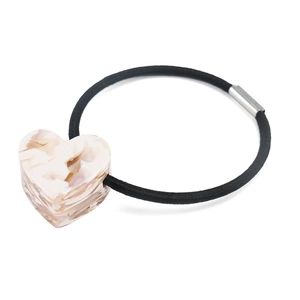 Gros plan du pendentif cœur en marbre rose sur élastique noir avec boucle argent