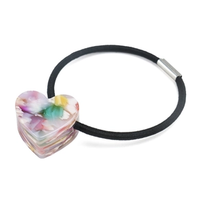 Détail d'un pendentif cœur à texture marbrée colorée sur un élastique noir robuste