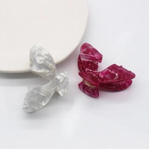 Detail von Haarklammern in Schmetterlingsform mit weißer und rosa Marmorstruktur