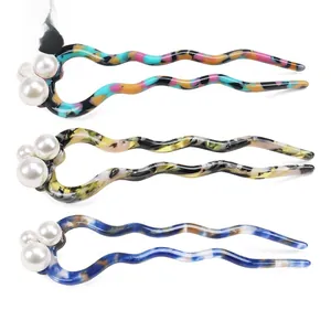 Detail showing wave-shaped U-shaped hairpins with marble patterns and three white pearls