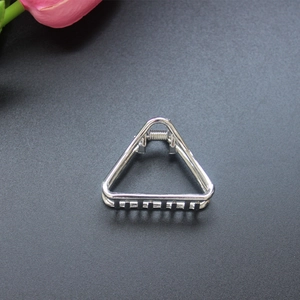 Vue macro d'une pince à cheveux triangulaire argentée avec finition métallique polie