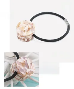 Detail view of cellulose acetate hair tie with marble pattern and elastic band