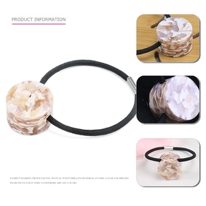 Detail of high-elasticity hair tie featuring geometric marbled acetate cylinder accents