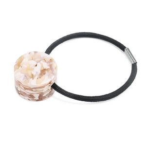 Detailed macro view of the acetate hair ring featuring elegant ivory marble texture and elastic cord