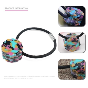 Detailed close-up of a floral acetate hair tie with abstract oil painting texture