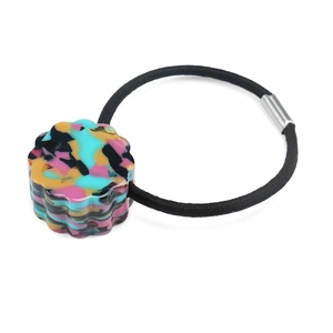 Detailed view of elastic hair tie with colorful tortoiseshell resin bead and metal joint