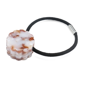 Detail of high-elastic hair tie featuring a round marble acetate charm and silver metal buckle