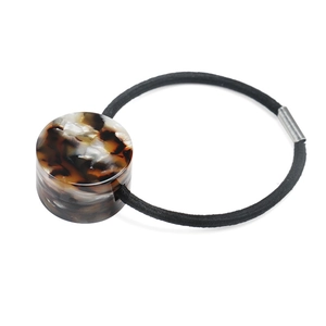 Detail of tortoiseshell acetate cylinder bead on high-elastic black hair tie band