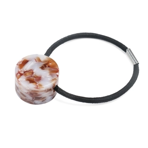 Detail of high-elasticity black hair tie with marble textured resin cylinder bead