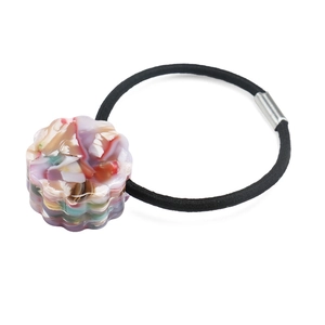 Close-up of elastic hair tie with floral marble texture acetate charm and silver clasp