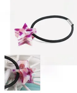 Dettaglio macro della stella in acetato su elastico nero per capelli ad alta elasticità