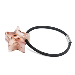 Dettaglio dell'elastico per capelli con stella in acetato e trama marmorizzata marrone