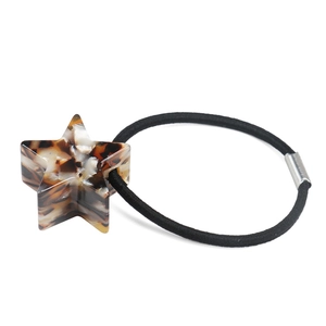 Dettaglio dell'elastico per capelli con stella in acetato tartarugato e clip in metallo