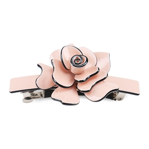 Detailed macro view of pink acrylic rose flower hair clip with black petal outlines