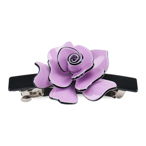 Detail view of a purple acrylic rose hair clip with elegant black edges and a metal spring