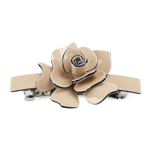 Detailed view of beige rose hair clip with black edges and silver metal spring clip
