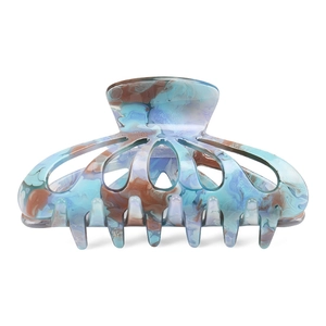 Detail of large acetate hair claw with blue-brown marble texture and hollow floral design