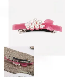 Detailed view of pink cellulose acetate hair clip with pearls and metal spring back
