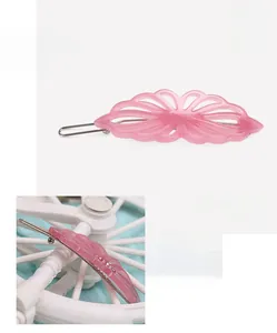 Detail of pink acetate hair clip with hollow petal texture and sparkling rhinestones