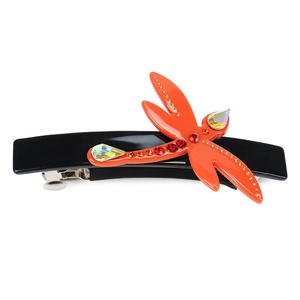 Detail view of a handcrafted dragonfly hair clip with colorful crystals and red rhinestones