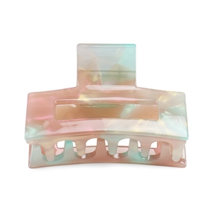 Close-up of holographic acetate hair claw clip with colorful geometric cutout design
