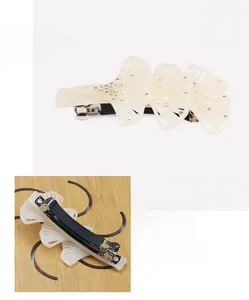 Détail d'une pince à cheveux feuille de ginkgo crème avec perles et strass brillants