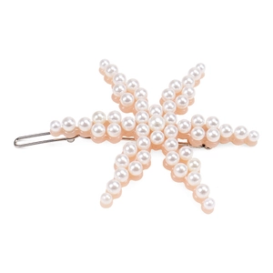 Détail d'une pince à cheveux étoile de mer rose avec des perles blanches incrustées