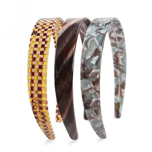 Three-piece set of acetate headbands featuring checkerboard, wood grain, and marble textures