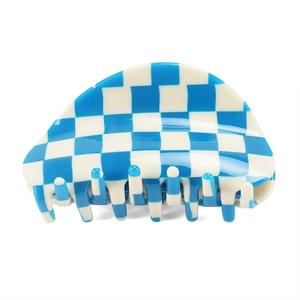 Close-up of blue and white checkered acetate hair claw clip with glossy finish