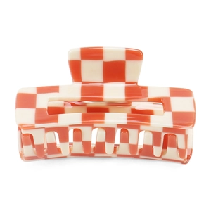 Detail of a rectangle checkerboard hair claw clip in orange and beige with glossy finish