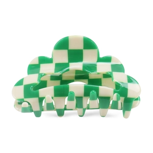 Detail view of a green and white checkered cloud shaped hair claw clip with smooth finish