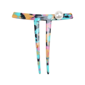 Close-up of marble pattern acetate hair fork with a white pearl accent on top