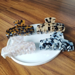 Detail of four acetate hair claws in various patterns like tortoiseshell and marble