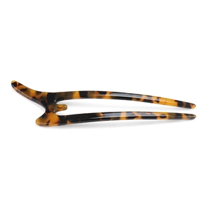 Macro detail of U-shaped tortoiseshell acetate hair pin showing leopard pattern texture