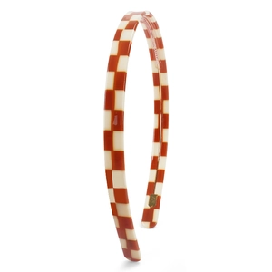 Detail view of red and cream checkerboard acetate headband with non-slip inner teeth grip